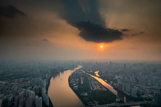 城市 aerial view 有河 有建筑 有天空中的太阳。
