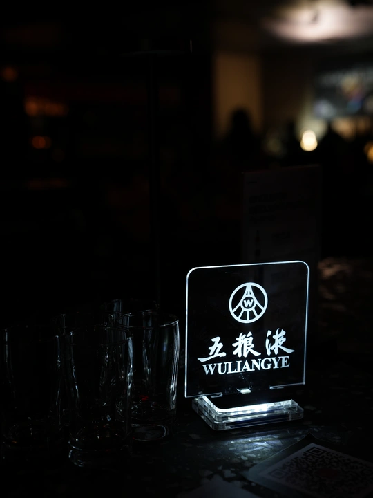 桌子上有一个标志和眼镜 在一个黑暗的房间里。