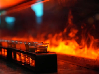 在壁炉前 酒吧上摆放着饮料的玻璃杯。