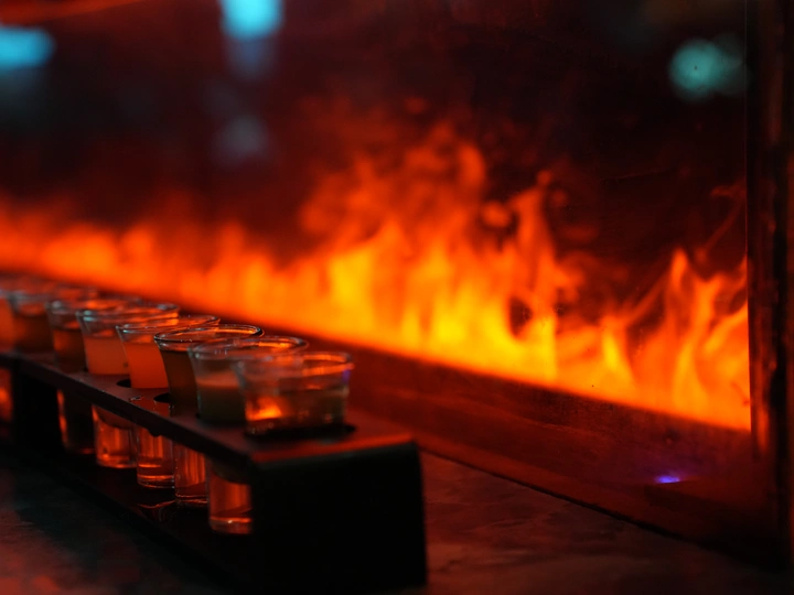 在壁炉前 眼镜里装满了饮料 火焰和蜡烛在旁边燃烧。