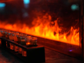 在壁炉前 眼镜里装满了饮料 火焰和蜡烛在旁边燃烧。