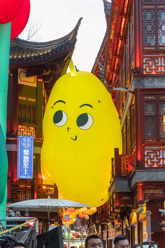人们走在街上 气球上挂着眼睛形状的装饰