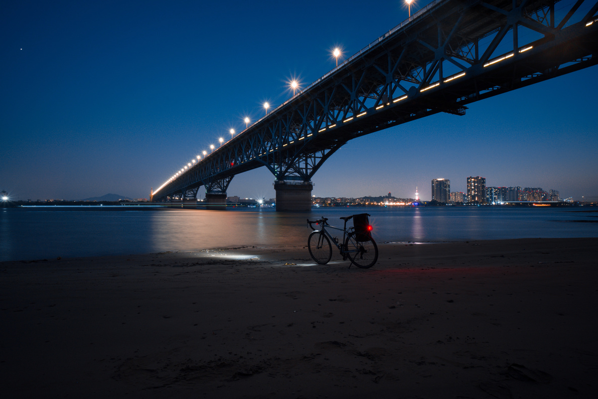 桥下水域夜晚停着一辆自行车