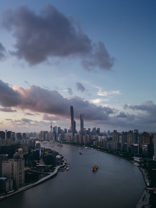 城市黄昏时的天际线 高耸的建筑和水中停泊的船。