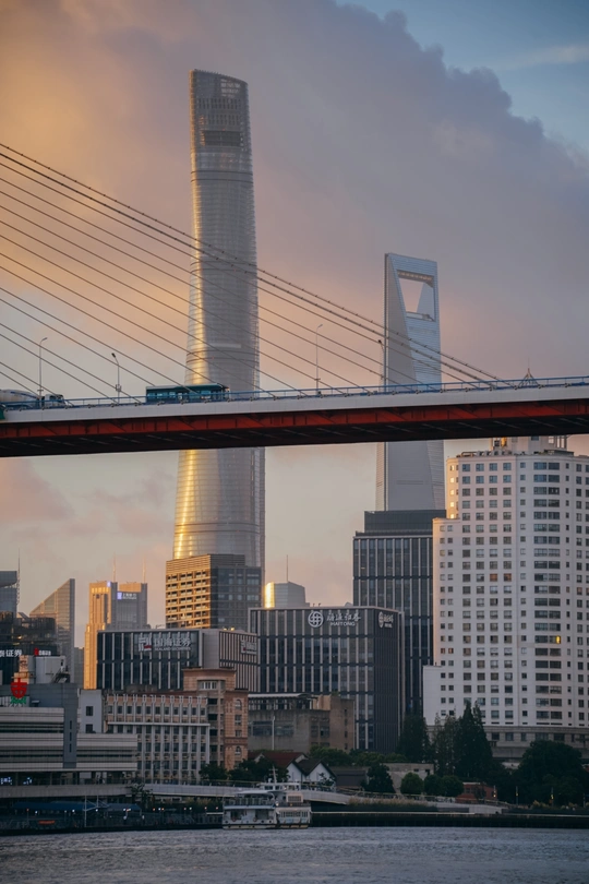 夕阳下 一座摩天大楼和一个横跨水面的桥