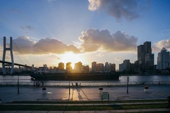 太阳落在了城市的轮廓线上 这座城市旁边有一条河。