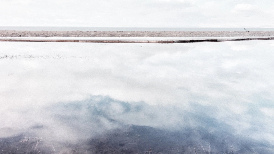 消防栓在水面上反射出天空和云朵。