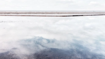 消防栓在水面上反射出天空和云朵。