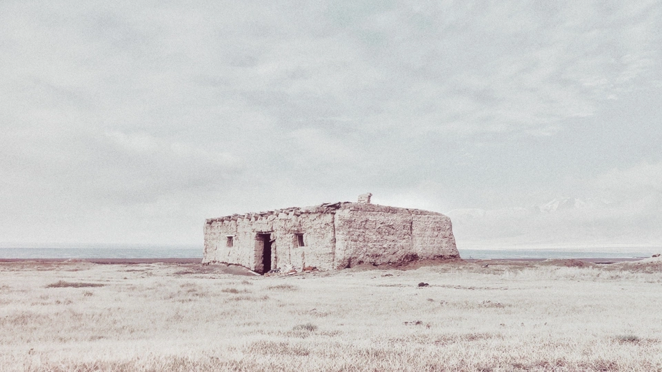一座古老的石头建筑孤独地屹立在原野上。
