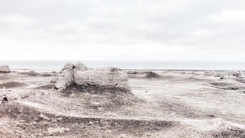 在沙漠中央的海滩上的一座沙堡 背景是海洋。