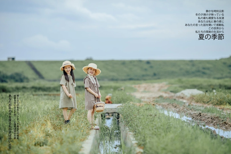 一名妇女和一名儿童穿过被洪水淹没的田地