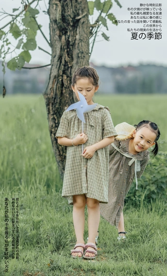 两个小女孩在树旁的田野里玩耍