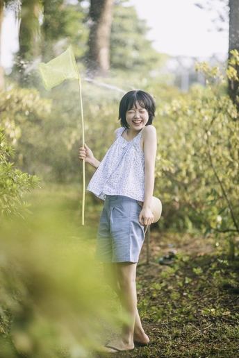 一位年轻女孩穿过森林中的花园