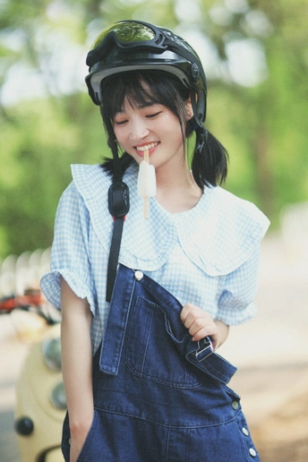 一位穿着蓝色工作服和头盔的年轻女子