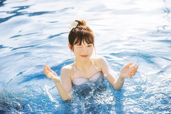 一个年轻女子在蓝色游泳池中游泳