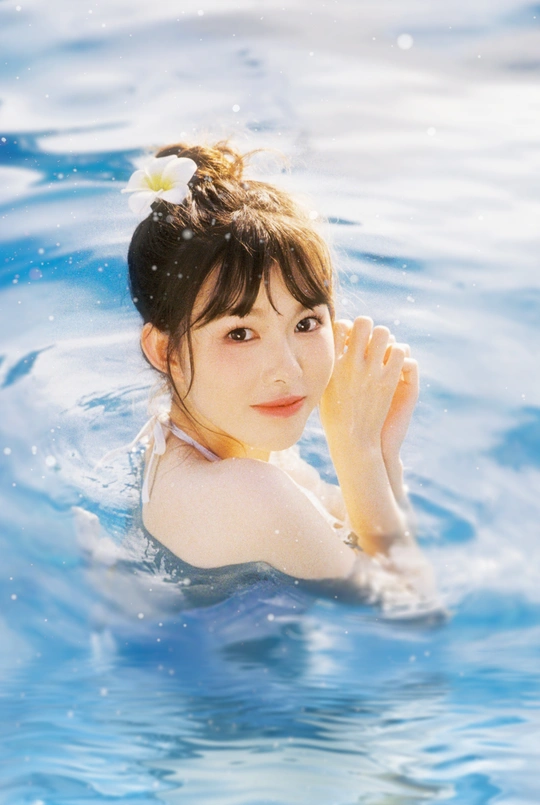一个年轻女子在一个清澈的蓝色泳池中游泳
