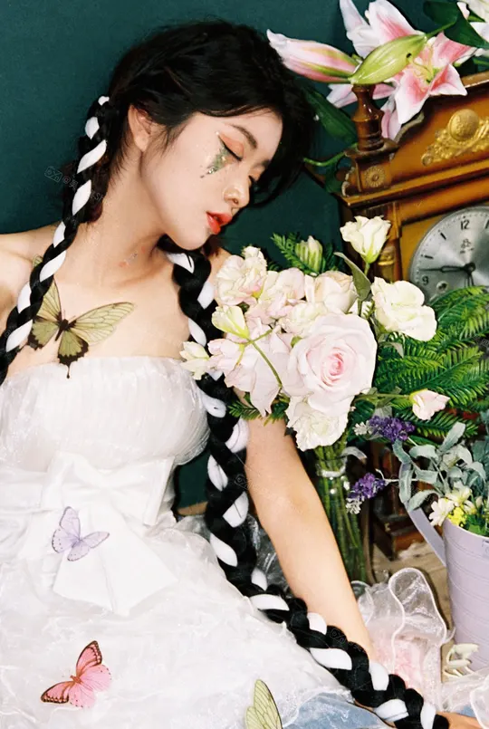 一位美丽的年轻女子穿着一件白色连衣裙 头发编成辫子 坐在时钟前面 头上戴着花。