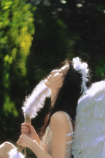 一位拥有白色羽翼的年轻女子拿着羽毛