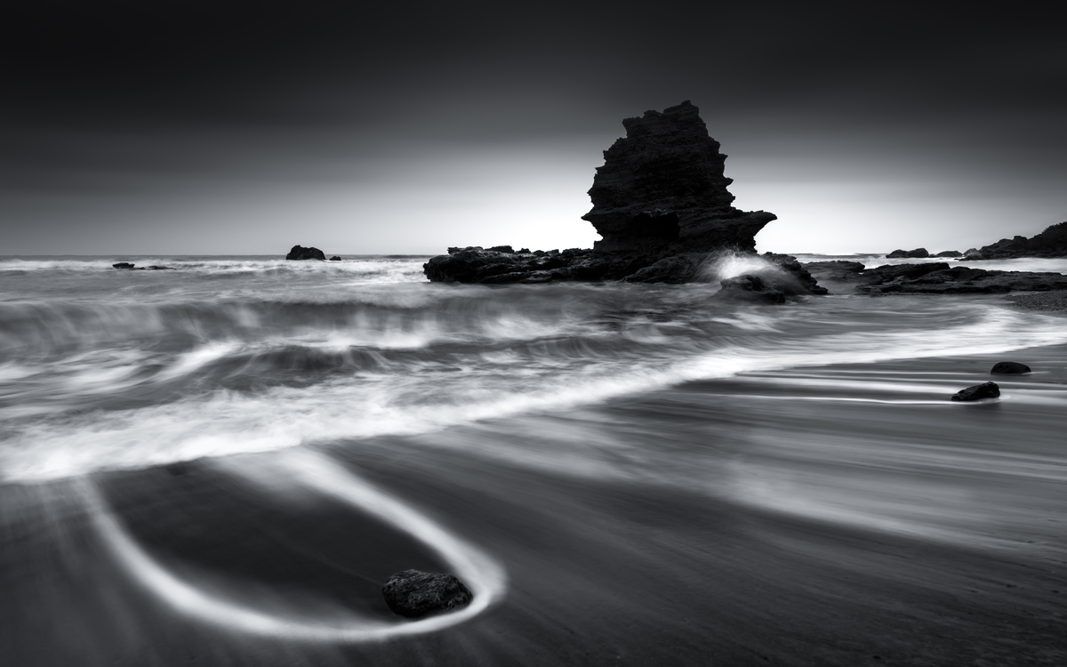 黑白长曝光海滩上的波浪、沙子和岩石