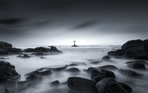 一张黑白照片 夜晚的大海 有船在水中 有雾中的灯塔。