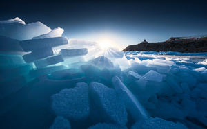 太阳透过冰山 在海洋的蓝色水域中漂浮着冰块。