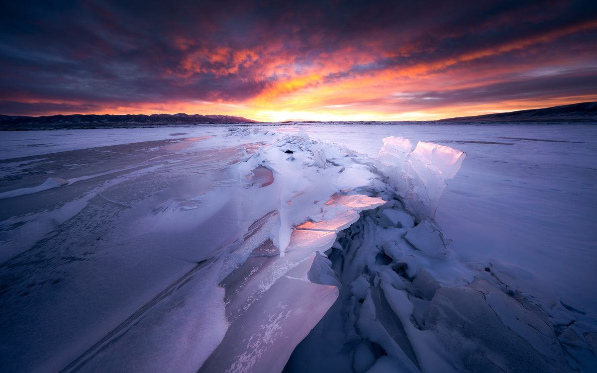 雪覆盖的冰冻湖 天空中太阳