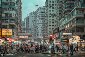 人群中的人们穿越一座拥有高楼大厦的城市拥挤的街道。