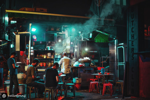 夜晚的黑暗街道上 人们坐在桌子旁。