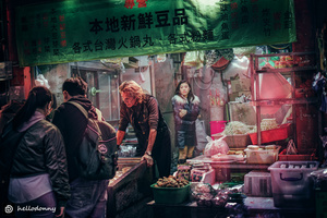一位站在市场前卖食物的女人