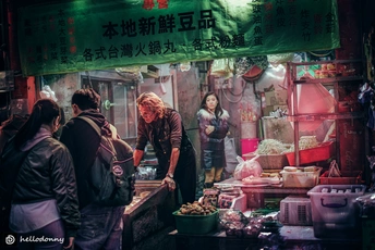 一位站在市场前卖食物的女人