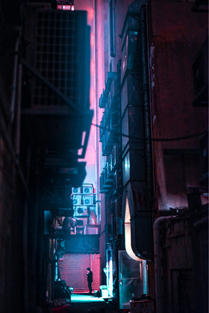 夜晚的黑暗小巷 有人站在小巷里 建筑物上有一个红灯。