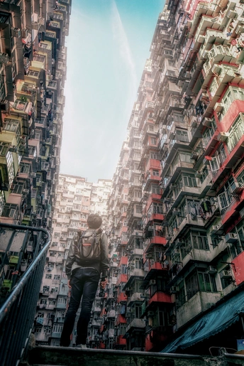 一个人站在城市中高楼之间的楼梯上