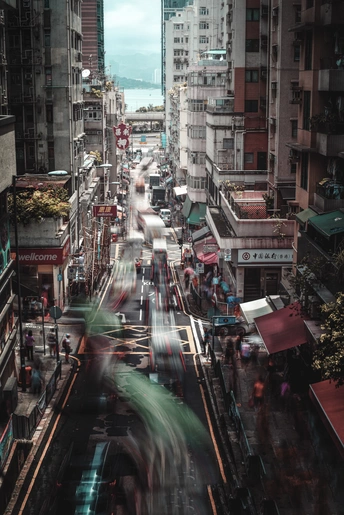 一条充满汽车和人的城市街道 旁边有高大的建筑。