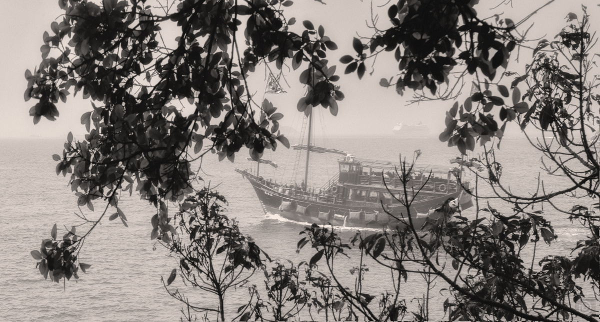 一张黑白照片 一艘船在大片水域中航行。