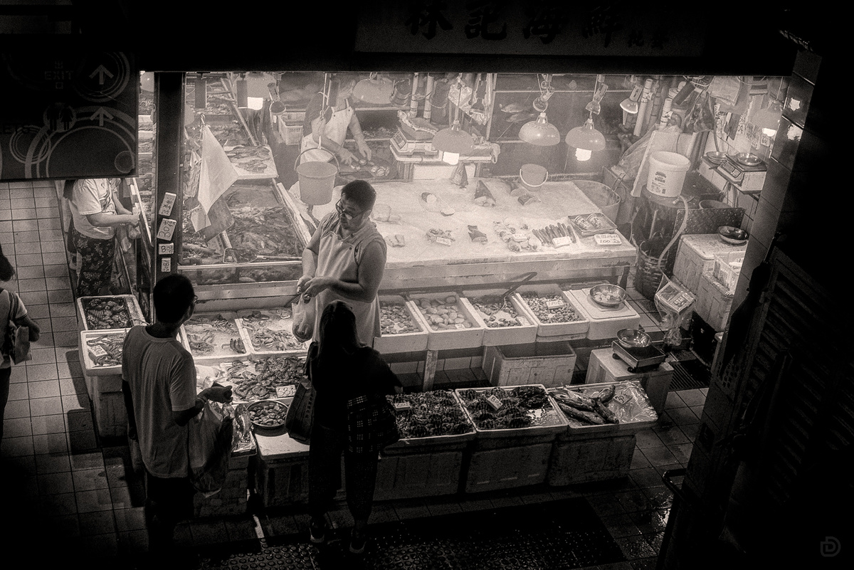 一张黑白照片 一对男女站在市场里