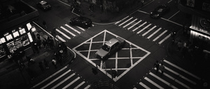一张城市夜晚的黑白照片 人们穿过街道。
