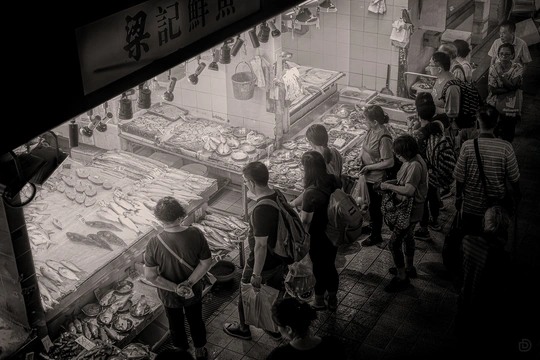 一些人在鱼市周围看着海鲜。