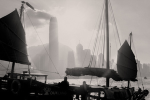 一张黑白照片 展示了一个港口 船只在大雾中航行 远处是一座大城市。