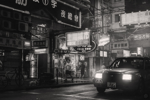 一张黑白的城市夜景照片 有汽车在街上行驶。