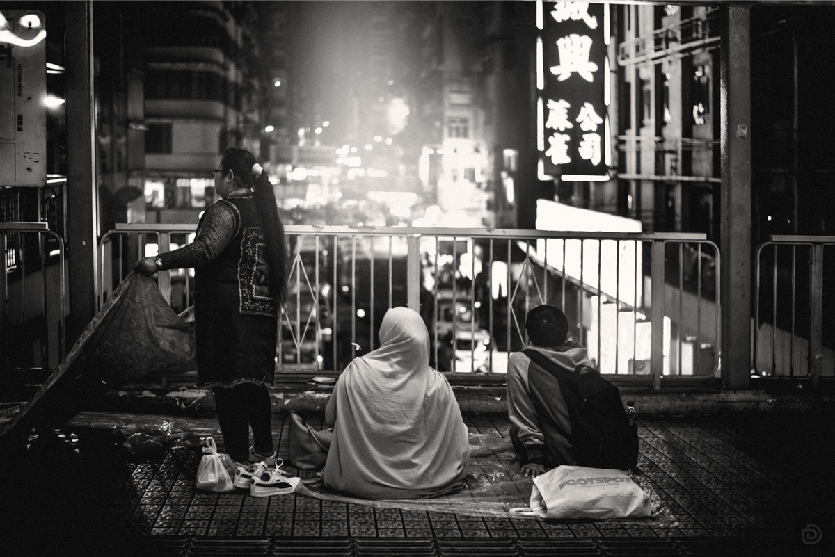 一张黑白照片 一对男女坐在城市街道上夜间