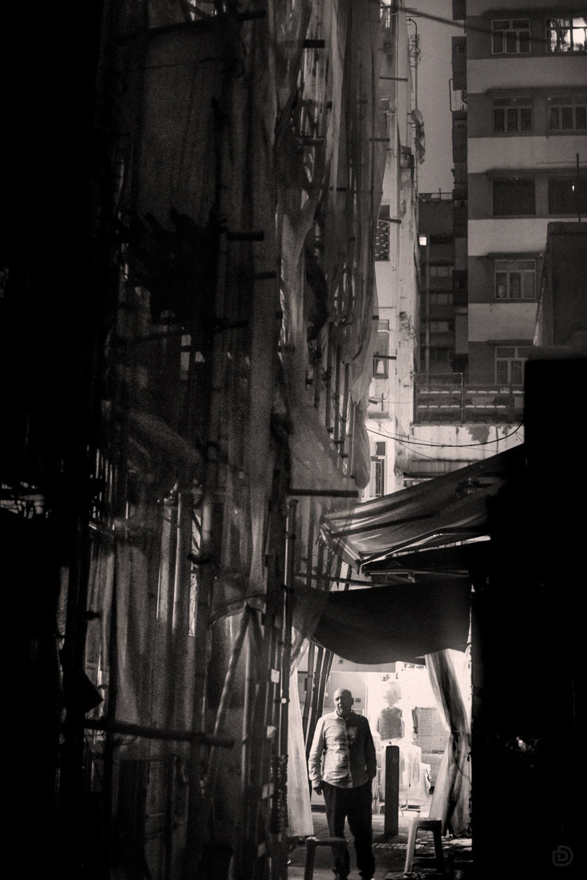夜晚的黑白狭窄街道 高楼大厦 中间站着一个人。