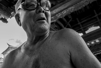 戴眼镜的男子站在一个金属结构前