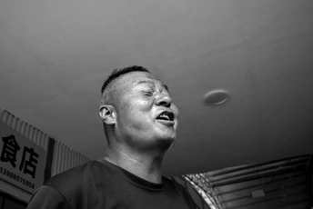 一个站在天花板下方的男子手里拿着一个球