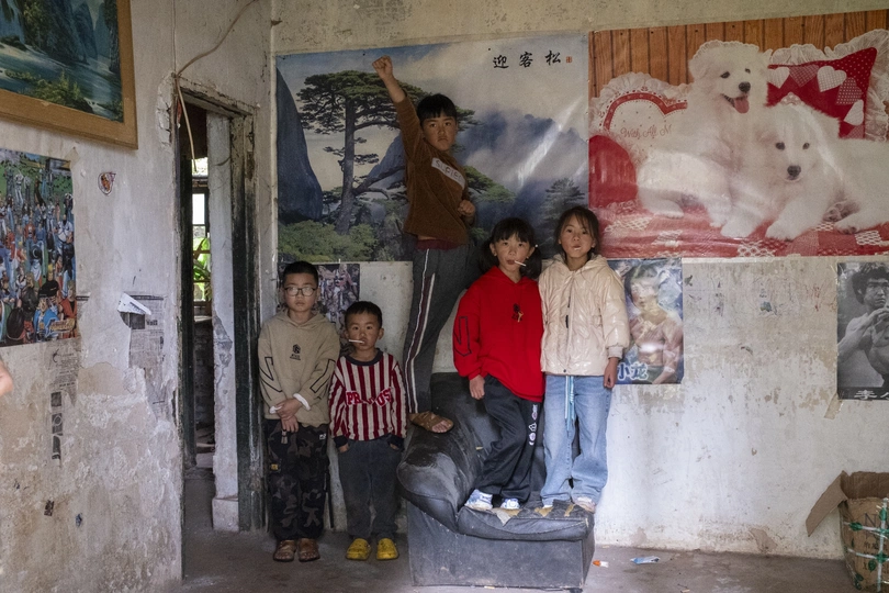 一栋建筑中的一间房间 墙上挂着一张动物的海报 一个年轻男孩在为拍照做姿势。