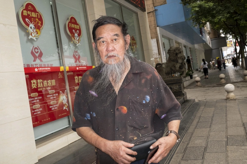 一个留着长胡子的老人站在人行道上。