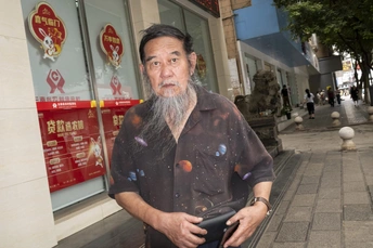 一个留着长胡子的老人站在人行道上。