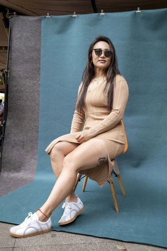 一个戴太阳镜的女人坐在椅子上 双腿交叉