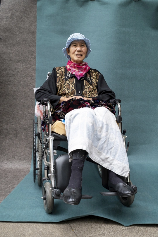 一位老太太坐在椅子上 双腿交叉