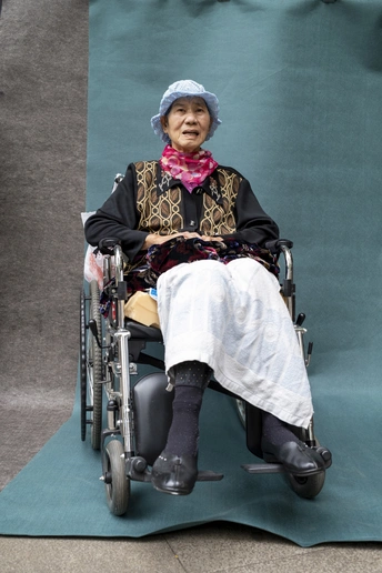 一位老太太坐在椅子上 双腿交叉