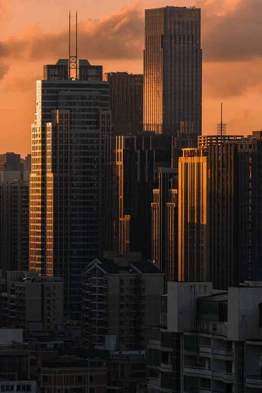 夕阳西下 落日余晖映照在高楼大厦的天际线上。